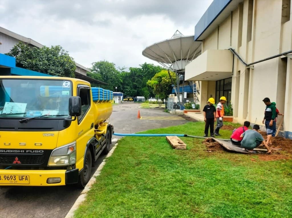 Teknisi mengatur pompa truk sedot untuk pekerjaan volume besar.